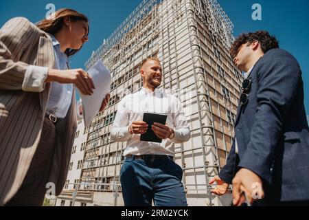 Jeunes ingénieurs discutant. Ingénieurs en construction parlant et debout sur un chantier de construction Banque D'Images