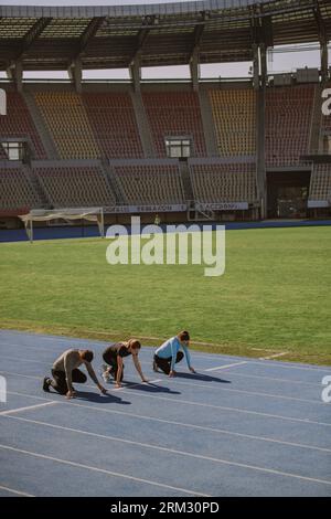 Un athlète masculin et deux athlètes féminins se préparent au sprint Banque D'Images