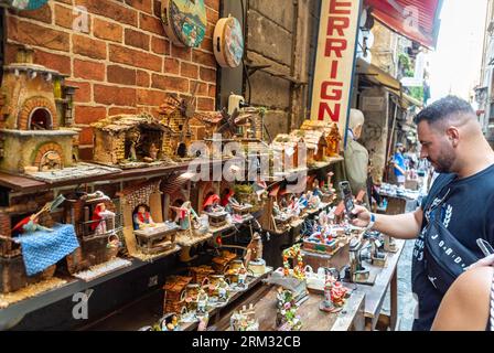 Naples, Italie, un homme italien regardant via San Gregorio Armeno, célèbre pour presepi (berceaux de Noël). Banque D'Images