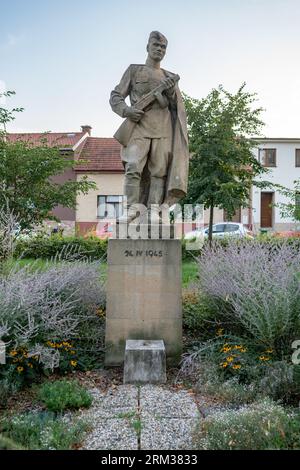 Statue d'un soldat de l'Armée rouge tenant une mitrailleuse (stylisée PPSh-41 avec un chargeur à tambour) de 1948 par Stanislav Hanzl à Šlapanice, Moravie. Banque D'Images