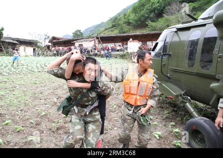 Bildnummer : 60134624 Datum : 16.07.2013 Copyright : imago/Xinhua (130716) -- WENCHUAN, 16 juillet 2013 (Xinhua) -- des travailleurs humanitaires transfèrent un enfant blessé à un hélicoptère dans le canton de Caopo du comté de Wenchuan, dans le sud-ouest de la Chine, province du Sichuan, 16 juillet 2013. Le commandement de la zone militaire de Chengdu de l Armée populaire de libération (PLA) a envoyé des hélicoptères pour aider aux opérations de secours dans le comté de Wenchuan, qui a été touché par les inondations. Une unité aérienne a envoyé trois hélicoptères avec 19 travailleurs humanitaires et 7,5 tonnes de matériel dans 12 vols vers le canton de Caopo dans le comté de Wenchuan, qui a souffert Banque D'Images