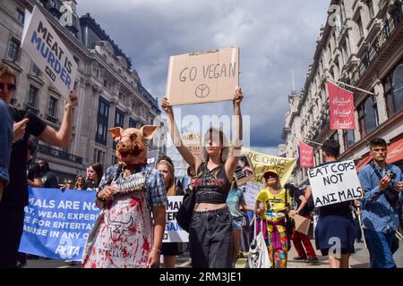 Londres, Royaume-Uni. 26 août 2023. Un manifestant tient une pancarte « Go vegan » et un autre porte un masque de cochon pendant la manifestation à Regent Street. Les foules ont défilé dans le centre de Londres pendant la Marche nationale des droits des animaux, exigeant la fin de toutes les formes d'exploitation et d'abus des animaux, et en soutien aux droits des animaux et au véganisme. Crédit : SOPA Images Limited/Alamy Live News Banque D'Images