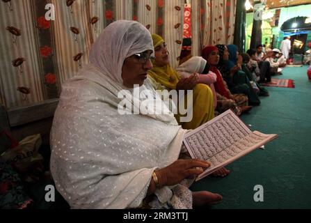 Bildnummer : 60329518 Datum : 06.08.2013 Copyright : imago/Xinhua (130806) -- SRINAGAR, 6 août 2013 (Xinhua) -- une femme musulmane cachemirienne récite les versets du Coran à l'intérieur du sanctuaire d'un saint soufi pour marquer Shab-E-Qadar, la 27e nuit du Saint mois de jeûne du Ramadan, dans la ville d'Anantnag, à environ 60 kilomètres au sud de Srinagar, capitale estivale du Cachemire contrôlé par les Indiens, le 6 août 2013. Shab-E-Qadr est l'anniversaire de la nuit où les musulmans croient que les premiers versets du livre Saint Coran ont été révélés au Prophète Muhammad par l'ange Gabriel. (Xinhua/Javed Dar) (Xinhua/Javed Dar) KASHMIR-SRINAG Banque D'Images