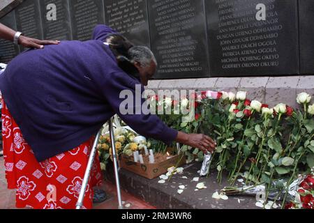 (130807) -- NAIROBI, Aug. 7, 2013 (Xinhua) -- A woman presents flowers to the 1998 bomb blast victims during the 15th annual commemoration at the August 7th Memorial Park in Nairobi, capital of Kenya, Aug. 7, 2013. Survivors congregated here on Wednesday to commemorate the victims of the 1998 bomb when the American Embassy building in Nairobi of Kenya and Dar-es-Salaam of Tanzania were bombed by terrorists on August 7th, 1998, killing 224 and injuring over 4,500. (Xinhua/Ali Alale)(cxy) KENYA-NAIROBI-1998 BOMB BLAST-COMMEMORATION PUBLICATIONxNOTxINxCHN Stock Photo