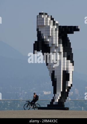 Vancouver, Canada. 26 août 2023. Un homme est vu avec des bâtiments enveloppés de brume dans le centre-ville de Vancouver, Colombie-Britannique, Canada, 26 août 2023. Samedi, le Grand Vancouver a poursuivi un avis sur la qualité de l'air pour la région métropolitaine de Vancouver en raison de la forte concentration de particules fines causée par la fumée des feux de forêt qui se propagent à travers la Colombie-Britannique. Crédit : Liang Sen/Xinhua/Alamy Live News Banque D'Images