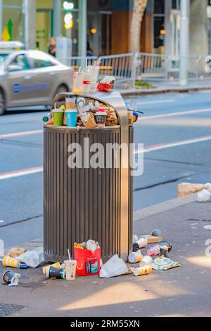 Tasses à café et conteneurs de nourriture dans la rue et les déchets débordant d'une poubelle trop pleine dans le centre de Sydney, Nouvelle-Galles du Sud, Australie Banque D'Images