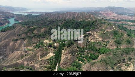 Yongjing, CHINE - 24 JUILLET 2023 - les montagnes vertes sur le plateau de Loess contrastent avec les eaux vertes du fleuve jaune à Yongjing, province du Gansu, Banque D'Images