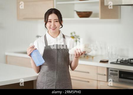 Femme asiatique pliant les serviettes et les rangeant Banque D'Images