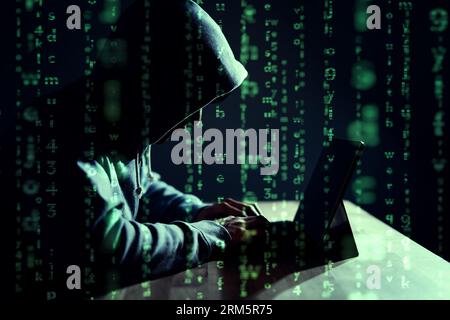 Pirate masculin écrivant du code sur un ordinateur portable Banque D'Images