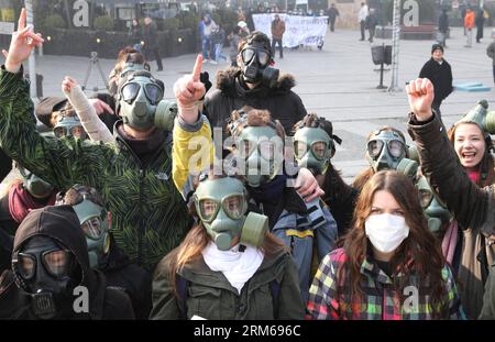 (131221) -- SKOPJE, 21 déc. 2013 (Xinhua) -- des militants écologistes macédoniens portant des masques à gaz participent à une manifestation sur la place principale de Skopje, capitale de la Macédoine, le 21 décembre 2013. Skopje et trois autres villes macédoniennes ont repéré une énorme pollution atmosphérique au cours des deux dernières semaines, ce qui a incité le gouvernement à émettre un certain nombre de mesures de protection et de recommandations. L'aéroport de Skopje a annulé presque tous les vols vers les aéroports d'Ohrid, Sofija et Belgrade en deux jours consécutifs en raison du brouillard et du smog causés par la pollution atmosphérique. (Xinhua/Darko Duridanski) (srb) MACÉDOINE-SKOPJE-PROTES Banque D'Images