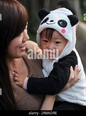 (140106) -- TAIPEI, 6 janv. 2014 (Xinhua) -- Une mère et son bébé portant un costume en forme de panda attendent de voir un petit panda géant Yuan Zai au zoo de Taipei à Taipei, dans le sud-est de la Chine de Taiwan, le 6 janvier 2014. Ce fut la première apparition publique de Yuan Zai. Le petit, né le 6 juillet 2013, est le premier bébé de Tuan Tuan et Yuan Yuan, qui ont été donnés en cadeau de bonne volonté à Taïwan par la Chine continentale. (Xinhua/Chen Yehua) (ry) CHINE-TAIPEI-GÉANT PANDA-CUB (CN) PUBLICATIONxNOTxINxCHN Taipei Jan 6 2014 XINHUA une mère et son bébé portant un costume en forme de Panda attendent le lac géant Panda CUB Yuan Zai AU zoo de Taipei Banque D'Images