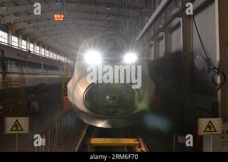 (140109) -- PÉKIN, 9 janvier 2014 (Xinhua) -- Un essai d'électricité statique est effectué après l'assemblage d'un train à grande vitesse CRH380A dans l'usine de fabrication de Qingdao Sifang Co. Ltd., à Qingdao, province du Shandong de l est de la Chine, 3 janvier 2014. Avec la vitesse la plus élevée de 380 km/h, le modèle du CRH380A est le train le plus rapide actuellement en service dans le monde. Le train CRH380A se distingue des produits étrangers en cause par quatre aspects clés : la forme extérieure de la locomotive, le bogie, l'étanchéité de la carrosserie de la voiture et les systèmes de contrôle du réseau et de traînage. Il a été conçu selon les normes internationales et en som Banque D'Images