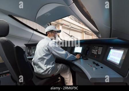 (140109) -- PÉKIN, 9 janv. 2014 (Xinhua) -- un ouvrier effectue un test d'électricité statique sur un train à grande vitesse CRH380 dans l'usine de fabrication de Qingdao Sifang Co. Ltd., à Qingdao, province du Shandong de l est de la Chine, 3 janvier 2014. Avec la vitesse la plus élevée de 380 km/h, le modèle du CRH380A est le train le plus rapide actuellement en service dans le monde. Le train CRH380A se distingue des produits étrangers en cause par quatre aspects clés : la forme extérieure de la locomotive, le bogie, l'étanchéité de la carrosserie de la voiture et les systèmes de contrôle du réseau et de traînage. Il a été conçu selon les normes internationales et dans certains domaines même Banque D'Images