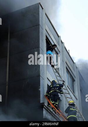 (140114) -- WENLING, 14 janvier 2014 (Xinhua) -- des sauveteurs tentent de sauver des personnes piégées dans un incendie d'usine à Wenling, dans la province du Zhejiang, dans l'est de la Chine, le 14 janvier 2014. Un incendie s'est déclaré mardi à 2:52 heures dans une usine de chaussures à Wenling City, faisant au moins 16 morts, a déclaré le gouvernement local. Les pompiers sont toujours à la recherche de survivants. Une enquête préliminaire sur la cause de l'incendie est en cours. (Xinhua/Lin Gensheng) (hdt) CHINA-ZHEJIANG-FIRE (CN) PUBLICATIONxNOTxINxCHN Wenling Jan 14 2014 sauvetage XINHUA essayez de sauver des célébrités piégées dans un incendie d'usine à Wenling East China S Zhej Banque D'Images