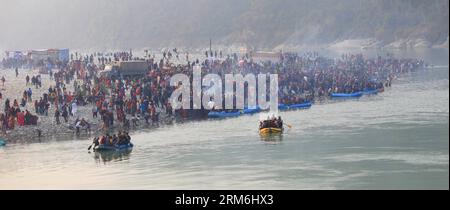 (140115) -- TANAHU, 15 janv. 2014 (Xinhua) -- des dévots hindous népalais se rassemblent au confluent des rivières Trishuli et Narayani lors du festival Maghe Sankranti à Devghat dans le district de Tanahu, Népal, le 15 janvier 2014. Maghe Sankranti est l'un des festivals importants au Népal, et est principalement marqué par les hindous népalais en prenant un bain rituel au confluent des rivières et en offrant des cultes dans divers temples, et en mangeant des spécialités spéciales comme chaku (mélasse durcie), til ko laddu (bonbons au sésame) et tarul (igname). (Xinhua/Sunil Sharma) NÉPAL-DEVGHAT-FESTIVAL PUBLICATIONxNOTxINxCHN Jan 15 2014 XINHUA N Banque D'Images