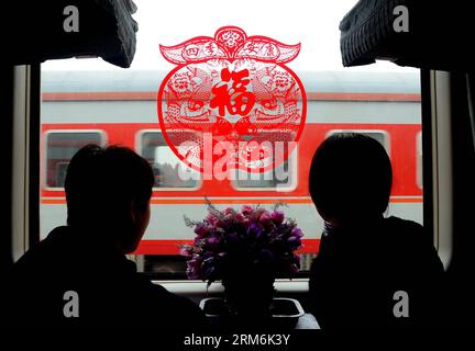 ZHENGZHOU - photo prise le 11 février 2013 montre des gens regardant par la fenêtre où collé une décoration avec le caractère chinois fu dedans dans le train K926 de Zhengzhou à Harbin. Le caractère chinois fu , qui signifie bonne chance , est commun partout en Chine pendant la fête du printemps. Il est populaire pour sa signification propice, peut également être interprété comme le bonheur , que le peuple chinois croit leur donner la bénédiction dans la nouvelle année à venir. (Xinhua/Wang Song) (zwx) CHINA-SPRING FESTIVAL-CHINESE CHARACTER FU (CN) PUBLICATIONxNOTxINxCHN Zhengzhou photo prise LE 11 2013 février Sho Banque D'Images