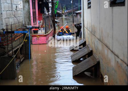 (140121) -- JAKARTA, 21 janv. 2014 (Xinhua) -- des membres de l'armée de l'air spéciale indonésienne se déplacent dans un bateau en caoutchouc pour évacuer les résidents d'un quartier inondé à Jakarta, Indonésie, 21 janvier 2014. Les inondations généralisées qui ont touché Jakarta, la capitale indonésienne, ont tué huit personnes et forcé plus de 60 000 autres à fuir les eaux lundi, alors que de fortes pluies torrentielles continuent de tromper la ville, a déclaré un responsable. (Xinhua/Zulkarnain)(bxq) INDONESIA-JAKARTA-FLOOD PUBLICATIONxNOTxINxCHN Jakarta Jan 21 2014 le personnel de la Force aérienne spéciale indonésienne de XINHUA se déplace dans un bateau en caoutchouc pour évacuer les résidents d'une inondation Banque D'Images