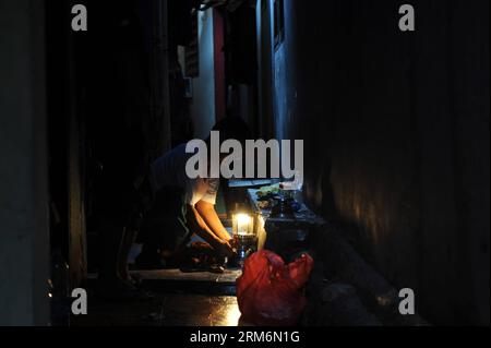 (140121) -- JAKARTA, 21 janv. 2014 (Xinhua) -- un homme allume une lampe à kérosène en raison de l'interruption de service causée par une inondation à Jakarta, Indonésie, le 21 janvier 2013. Les inondations causées par une forte averse ont tué huit personnes et forcé plus de 60 000 autres à fuir leur maison à Jakarta, a déclaré un responsable. (Xinhua/Veri Sanovri)(zhf) INDONESIA-JAKARTA-FLOOD PUBLICATIONxNOTxINxCHN Jakarta Jan 21 2014 XINHUA un homme allume une lampe à kérosène en raison de l'interruption de service CAUSÉE par les inondations à Jakarta Indonésie Jan 21 2013 les inondations CAUSÉES par les fortes pluies ont TUÉ huit célébrités et forcé plus de 60 000 OT Banque D'Images