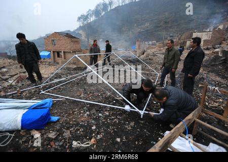 (140126) -- ZHENYUAN, 26 janv. 2014 (Xinhua) -- des gens ont installé une tente dans le village de Baojing Dong, dans le comté de Zhenyuan, dans la province du Guizhou, au sud-ouest de la Chine, le 26 janvier 2014. Un incendie s’est déclaré samedi à 11:30 heures dans le village et a détruit plus de 100 maisons. Le village de Baojing Dong, construit il y a 300 ans, est le plus grand village de Dong à Qiandongnan Miao et dans la préfecture autonome de Dong du Guizhou. C'était l'une des colonies les mieux préservées de Chine, connue pour ses anciennes habitations de style Dong. Elle compte 470 ménages et près de 2 000 habitants. Aucune victime n'a été signalée et la cause de Banque D'Images