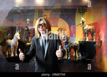 (140129) -- NEW YORK, 29 janvier 2014 (Xinhua) -- le musicien chinois Guo Feng pose devant sa vitrine d'exposition de chevaux cloisonnés après la cérémonie d'éclairage de l'Empire State Building à New York, aux États-Unis, le 29 janvier 2014. L'Empire State Building a organisé mercredi une cérémonie d'éclairage pour marquer le nouvel an lunaire chinois, l'année du cheval. (Xinhua/Wu Rong) US-NEW YORK-EMPIRE STATE BUILDING-LIGHTING CEREMONY PUBLICATIONxNOTxINxCHN New York Jan 29 2014 XINHUA musicien chinois Guo Feng pose devant sa vitrine d'exposition de chevaux cloisonnés après la cérémonie d'éclairage de l'Empire Banque D'Images