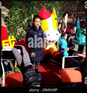 (140203) -- PÉKIN, 2 février 2014 (Xinhua) -- sur cette photo prise avec un smartphone le 2 février 2014, un jeune garçon pose pour des photos à côté d'une mascotte de cheval (2014 est l'année du cheval) à la foire du temple Yuanmingyuan à Pékin, capitale de la Chine. À Pékin, les foires du temple ont été un répertoire typique pendant la fête du printemps, qui est tombée le 31 janvier cette année. Les gens se divertissent aux foires du temple avec divers aliments et collations ainsi que des activités folkloriques. (Xinhua/Shen Bohan) (lmm) CHINE-PÉKIN-FESTIVAL DE PRINTEMPS-TEMPLE FAIR-SMARTPHONE (CN) PUBLICATIONxNOTxINxCHN Pékin février 2 2014 XINHUA Banque D'Images