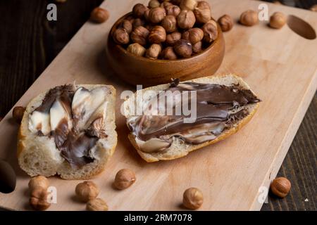 tranches de pain au beurre de chocolat sur la table, en cuisant un simple dessert sucré fait maison avec du beurre de chocolat et du pain blanc Banque D'Images
