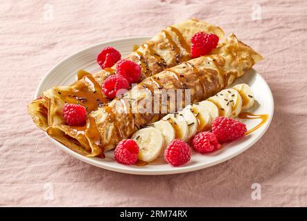 crêpes roulées fraîchement cuites avec fruits frais et sauce caramel Banque D'Images