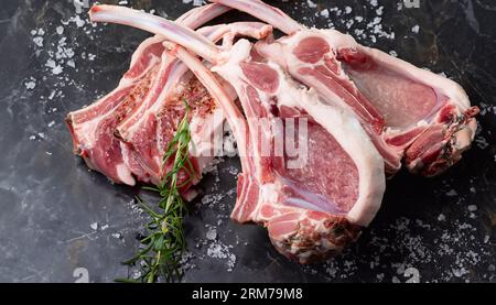 Viande entière crue d'agneau pleine jambes sur fond en bois. Vue de dessus Banque D'Images