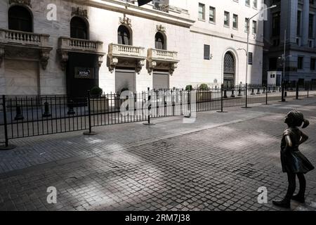 Vue de The Fearless Girl, une sculpture en bronze sur Broad Street en face du New York stock Exchange Building à Manhattan, New York. Banque D'Images