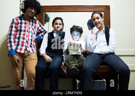 (140310) -- LE CAIRE, 10 mars 2014 (Xinhua) -- quatre membres de chœur jouent dans les coulisses avant leur représentation à l'Opéra du Caire au Caire, Égypte, le 13 novembre 2013. Dr. Nadia Abdelaziz Awad, professeur de musique à l'Université Helwan et mentor de certains chanteurs de l'Opéra du Caire, dirige une chorale d'enfants depuis plus de 20 ans. Malgré les convulsions de la société égyptienne depuis 2011, le Dr Nadia Abdelaziz Awad et les membres de la chorale des enfants adhèrent à des répétitions hebdomadaires et se produisent à l'Opéra du Caire de temps à autre. Quoi qu'il arrive, l'art continuera, Dr Nadia Abdelazi Banque D'Images