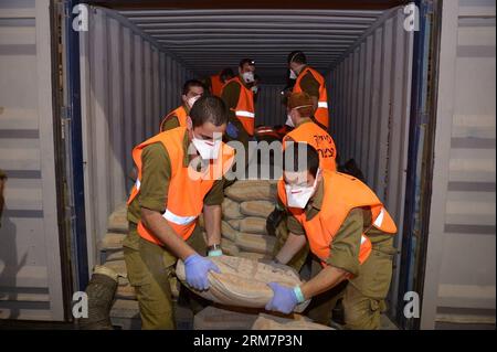 Photo prise le 9 mars 2014. Montre des soldats israéliens déchargeant des cargaisons sur un navire battant pavillon panaméen. L'armée israélienne a déclaré qu'elle avait effectué une perquisition mercredi dernier à bord du navire battant pavillon panaméen, nommé le KLOS-C, et a trouvé des dizaines de roquettes M-302 surface-surface de fabrication syrienne dissimulées sous des sacs de ciment, ajoutant que le mouvement chiite libanais Hezbollah a tiré ce type de roquette dans le nord d’Israël pendant la guerre de 33 jours en 2006. (Xinhua/Xinhua) ARMES SAISIES PAR ISRAËL PUBLICATIONxNOTxINxCHN la photo prise LE 9 2014 mars montre des soldats israéliens déchargeant des cargaisons SUR un drapeau panaméen Banque D'Images