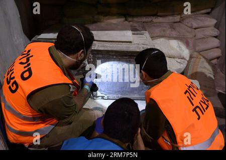 Photo prise le 9 mars 2014. Montre des soldats israéliens déchargeant des cargaisons sur un navire battant pavillon panaméen. L'armée israélienne a déclaré qu'elle avait effectué une perquisition mercredi dernier à bord du navire battant pavillon panaméen, nommé le KLOS-C, et a trouvé des dizaines de roquettes M-302 surface-surface de fabrication syrienne dissimulées sous des sacs de ciment, ajoutant que le mouvement chiite libanais Hezbollah a tiré ce type de roquette dans le nord d’Israël pendant la guerre de 33 jours en 2006. (Xinhua/Xinhua) ARMES SAISIES PAR ISRAËL PUBLICATIONxNOTxINxCHN la photo prise LE 9 2014 mars montre des soldats israéliens déchargeant des cargaisons SUR un drapeau panaméen Banque D'Images