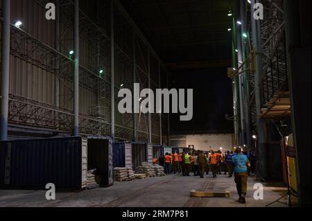 Photo prise le 9 mars 2014. Montre des soldats israéliens déchargeant des cargaisons sur un navire battant pavillon panaméen. L'armée israélienne a déclaré qu'elle avait effectué une perquisition mercredi dernier à bord du navire battant pavillon panaméen, nommé le KLOS-C, et a trouvé des dizaines de roquettes M-302 surface-surface de fabrication syrienne dissimulées sous des sacs de ciment, ajoutant que le mouvement chiite libanais Hezbollah a tiré ce type de roquette dans le nord d’Israël pendant la guerre de 33 jours en 2006. (Xinhua/Xinhua) ARMES SAISIES PAR ISRAËL PUBLICATIONxNOTxINxCHN la photo prise LE 9 2014 mars montre des soldats israéliens déchargeant des cargaisons SUR un drapeau panaméen Banque D'Images