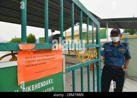 (140314) -- SELANGOR (MALAISIE), 14 mars 2014 (Xinhua) -- Un garde de sécurité se tient près d'une porte d'entrée d'une école à Port Klang, Malaisie, 14 mars 2014. Les écoles sont fermées le vendredi à cause de l'air malsain. L'indice de pollution atmosphérique (API) de Port Klang, situé à l'ouest de la capitale Kuala Lumpur, a atteint un niveau malsain vendredi, selon le site Web du ministère de l'Environnement de Malaisie. (Xinhua/Chong Voon Chung) (lmz) MALAYSIA-PORT KLANG-HAZE PUBLICATIONxNOTxINxCHN Selangor Malaysia Mars 14 2014 XINHUA un garde de sécurité se tient près d'une porte d'école à Port Sound Malaysia Mars 14 2 Banque D'Images