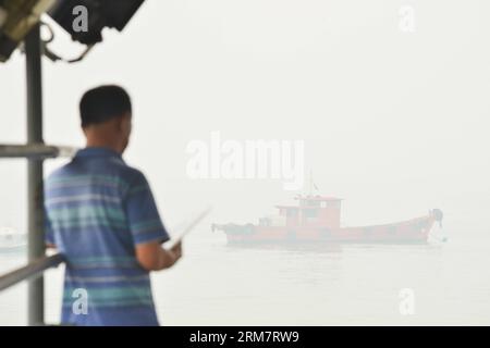 (140314) -- SELANGOR (MALAISIE), 14 mars 2014 (Xinhua) -- Un touriste attend pour monter à bord d'un bateau à Port Klang, Malaisie, 14 mars 2014. Les écoles sont fermées le vendredi à cause de l'air malsain. L'indice de pollution atmosphérique (API) de Port Klang, situé à l'ouest de la capitale Kuala Lumpur, a atteint un niveau malsain vendredi, selon le site Web du ministère de l'Environnement de Malaisie. (Xinhua/Chong Voon Chung) (lmz) MALAYSIA-PORT KLANG-HAZE PUBLICATIONxNOTxINxCHN Selangor Malaysia Mars 14 2014 XINHUA un touriste attend pour monter à bord d'un bateau à Port Sound Malaysia Mars 14 2014 les écoles sont fermées O Banque D'Images