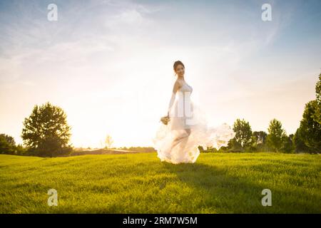 Heureuse mariée dansant sur l'herbe