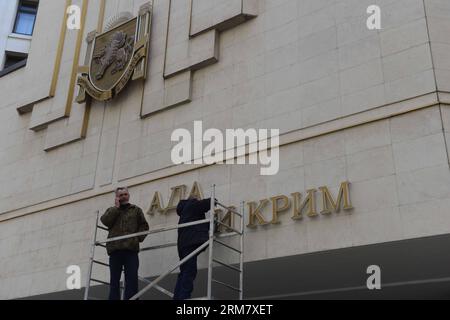(140318) -- SIMFEROPOL, 18 mars 2014 (Xinhua) -- des travailleurs démontent les panneaux ukrainiens sur le Parlement de Crimée à Simferopol, République de Crimée, le 18 mars 2014. Le président russe Vladimir Poutine et les dirigeants de Crimée ont signé mardi un traité acceptant la République de Crimée et la ville de Sébastopol comme faisant partie du territoire russe. (Xinhua/Sadate) (cru) CRIMÉE-SIMFEROPOL-RUSSIE-TREATY PUBLICATIONxNOTxINxCHN Banque D'Images