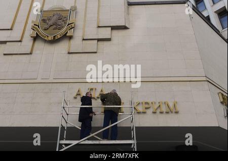 (140318) -- SIMFEROPOL, 18 mars 2014 (Xinhua) -- des travailleurs démontent les panneaux ukrainiens sur le Parlement de Crimée à Simferopol, République de Crimée, le 18 mars 2014. Le président russe Vladimir Poutine et les dirigeants de Crimée ont signé mardi un traité acceptant la République de Crimée et la ville de Sébastopol comme faisant partie du territoire russe. (Xinhua/Sadate) (cru) CRIMÉE-SIMFEROPOL-RUSSIE-TRAITÉ PUBLICATIONxNOTxINxCHN Simferopol Mars 18 2014 les travailleurs DE XINHUA démantelent les panneaux ukrainiens SUR LE Parlement à Simferopol la République de Crimée Mars 18 2014 le Président russe Vladimir Banque D'Images