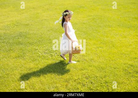 Jolie fille de fleur jouant sur l'herbe Banque D'Images