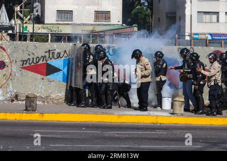 Des membres de la police nationale bolivarienne montent la garde lors d une manifestation d étudiants à Altamira, municipalité de Chacao, à l est de Caracas, Venezuela. le 22 mars 2014. (Xinhua/Manuel Hernandez) (rt) VENEZUELA-CARACAS-SOCIETY-PROTEST PUBLICATIONxNOTxINxCHN les membres de la police nationale bolivarienne tiennent la garde lors d'une manifestation étudiante dans la municipalité d'Altamira Chacao S est de Caracas Venezuela LE 22 2014 mars XINHUA Manuel Hernandez RT Venezuela manifestation de la Société de Caracas PUBLICATIONxNOTxINxCHN Banque D'Images