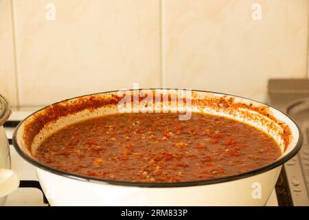 Adjika épicé maison à cuisiner dans une casserole à la maison dans la cuisine, adjika épicé à cuisiner, sauce Banque D'Images