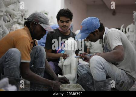 (140325) -- VARANASI, 25 mars 2014 (Xinhua) -- des artisans travaillent sur une sculpture en pierre dans une usine de Varanasi, une vieille ville sainte hindoue située sur la rive du Gange, en Inde, le 25 mars 2014. L'industrie de la sculpture sur pierre de Varanasi, ville sainte riveraine, est en plein essor. Les artistes des États environnants produisent non seulement des sculptures de dieux et de déesses, mais aussi des humains. Les sculptures en pierre de Varanasi, étant fantaisie dans le style et le design, attirent de plus en plus de clients chaque année et ils sont vendus à travers l'Inde et les marchés étrangers. (Xinhua/Zheng Huansong) INDE-VARANASI-SCULPTURE SUR PIERRE PUBL Banque D'Images