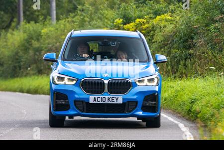 Whittlebury,Northants,UK -Aug 26th 2023 : 2021 bleu hybride électrique BMW X1 XDrive 25e M voiture de sport voyageant sur une route de campagne anglaise Banque D'Images