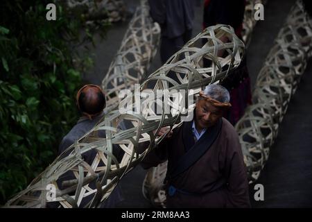 (140405) -- DUJIANGYAN, 5 avril 2014 (Xinhua) -- des gens se produisent lors de la cérémonie pour offrir des sacrifices à l'eau au barrage de Dujiang, un ancien projet d'irrigation mais toujours opérationnel, dans la province du Sichuan du sud-ouest de la Chine, le 5 avril 2014, jour du festival chinois traditionnel Qingming. Le plus ancien projet d irrigation au monde a été construit en 256 av. J.-C. par le gouverneur local Li Bing pendant les États belligérants (475-221 av. J.-C.). La cérémonie a lieu chaque année au Festival de Qingming pour prier pour un temps favorable et commémorer les contributions de Li Bing. (Xinhua/Xu Ru) (wf) CHINE-SICHUAN-DUJIANG DA Banque D'Images