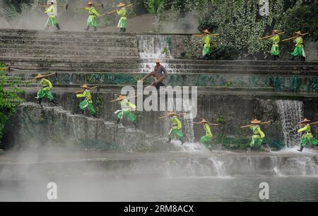 (140405) -- DUJIANGYAN, 5 avril 2014 (Xinhua) -- des gens se produisent lors d'une cérémonie pour offrir des sacrifices à l'eau au barrage de Dujiang, un ancien projet d'irrigation mais toujours en activité, dans la province du Sichuan du sud-ouest de la Chine, le 5 avril 2014, jour du festival chinois traditionnel du Qingming. Le plus ancien projet d irrigation au monde a été construit en 256 av. J.-C. par le gouverneur local Li Bing pendant les États belligérants (475-221 av. J.-C.). La cérémonie a lieu chaque année au Festival de Qingming pour prier pour un temps favorable et commémorer les contributions de Li Bing. (Xinhua/Jiang Hongjing) (wf) CHINE-SICHUAN-DUJ Banque D'Images