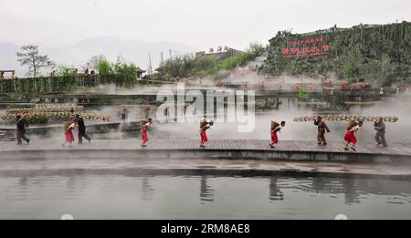 (140405) -- DUJIANGYAN, 5 avril 2014 (Xinhua) -- des gens se produisent lors d'une cérémonie pour offrir des sacrifices à l'eau au barrage de Dujiang, un ancien projet d'irrigation mais toujours en activité, dans la province du Sichuan du sud-ouest de la Chine, le 5 avril 2014, jour du festival chinois traditionnel du Qingming. Le plus ancien projet d irrigation au monde a été construit en 256 av. J.-C. par le gouverneur local Li Bing pendant les États belligérants (475-221 av. J.-C.). La cérémonie a lieu chaque année au Festival de Qingming pour prier pour un temps favorable et commémorer les contributions de Li Bing. (Xinhua/Jiang Hongjing) (wf) CHINE-SICHUAN-DUJ Banque D'Images