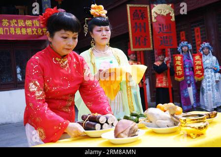 (140405) -- SUZHOU, 5 avril 2014 (Xinhua) -- des artistes folkloriques ont posé des offrandes sur une table pour montrer leur respect aux ancêtres lors d'un défilé du Festival Qingming dans la rue Shantang de Suzhou, dans la province du Jiangsu, dans l'est de la Chine, le 5 avril 2014. Le Festival de Qingming, qui est tombé samedi cette année, est observé par le peuple chinois pour rendre hommage aux ancêtres et pleurer les défunts. (Xinhua/Wang Jianzhong) (lmm) CHINA-JIANGSU-SUZHOU-QINGMING FESTIVAL-PARADE (CN) PUBLICATIONxNOTxINxCHN Suzhou avril 5 2014 les artistes folkloriques XINHUA présentent des offrandes SUR une table pour montrer le respect des ancêtres lors d'un Para du Festival Qing Ming Banque D'Images