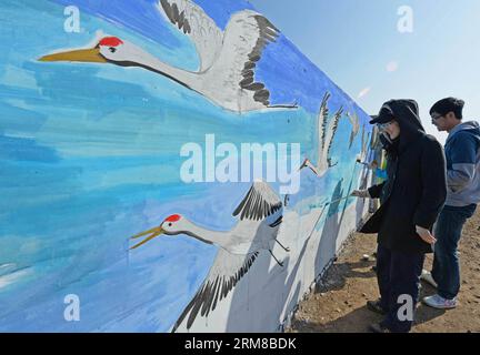 Des volontaires dessinent des grues à couronne rouge sur un mur à la station de sauvetage de Daqinghe de l'Association pour la conservation de la faune sauvage du comté de Laoting dans la ville de Tangshan, province du Hebei, dans le nord de la Chine, le 6 avril 2014. Des bénévoles pour la protection des oiseaux sont venus décorer le mur extérieur de la station de sauvetage le 6 avril, un geste pour soutenir la conservation de la faune. (Xinhua/Yan Jun) (lfj) CHINA-HEBEI-TANGSHAN-WILDLIFE CONSERVATION (CN) PUBLICATIONxNOTxINxCHN des volontaires dessinent des grues couronnées rouges SUR un mur À la station de sauvetage de l'Association pour la conservation de la faune du comté de Tang Shan City nord de la Chine S Hebei province avril 6 2 Banque D'Images