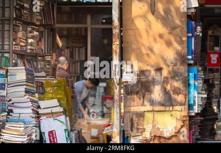 De vieux livres entassés dans la porte ouverte d'une librairie d'occasion délapide à Giai Phong Road, Hanoi, Vietnam. Banque D'Images