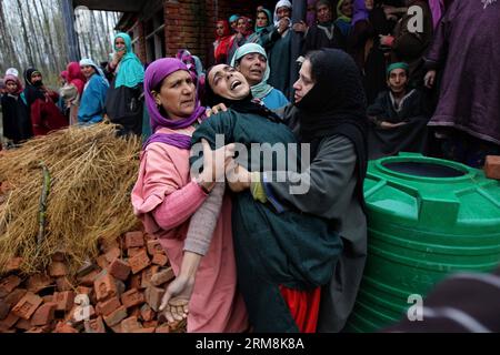 Les femmes cachemiriennes réconfortent un parent en colère d’un chef de corps rural Mohammed Amin Pandith lors de sa procession funéraire dans le village de Gulzarpora du district de Pulwama, à environ 35 km au Sud de Srinagar, capitale d’été du Cachemire contrôlé par l’Inde, le 18 avril 2014. Des militants présumés ont abattu une tête de corps rurale, un travailleur politique de base affilié à la principale opposition de la région, le Parti démocratique populaire (PDP) pro-indien, dans le Cachemire contrôlé par l Inde, a déclaré vendredi la police. (Xinhua/Javed Dar) CACHEMIRE-SRINAGAR-TRAVAILLEUR POLITIQUE-ABATTU PUBLICATIONxNOTxINxCHN Kashmiri femmes réconfortent un parent de Banque D'Images